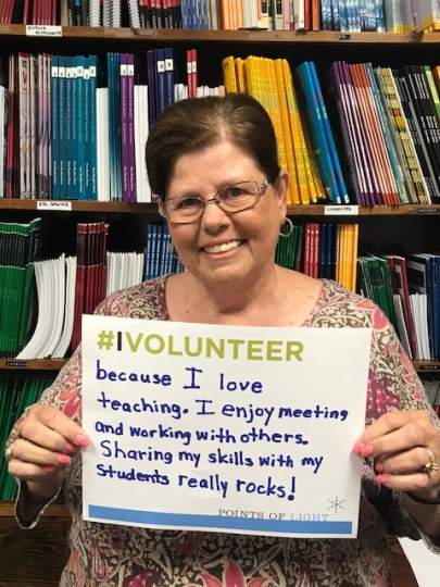 Literacy Services Volunteer holding "Why I Volunteer Sign".